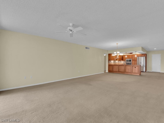 unfurnished living room with light carpet, a textured ceiling, and ceiling fan with notable chandelier