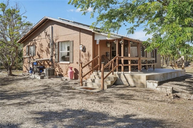 rear view of property featuring central AC unit and a sunroom