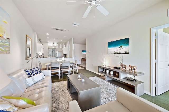 carpeted living room with ceiling fan