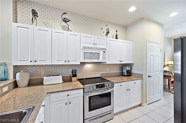 kitchen with white cabinetry, sink, light tile floors, and stainless steel appliances