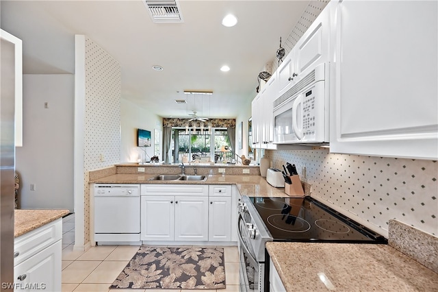 kitchen with white appliances, sink, and white cabinetry