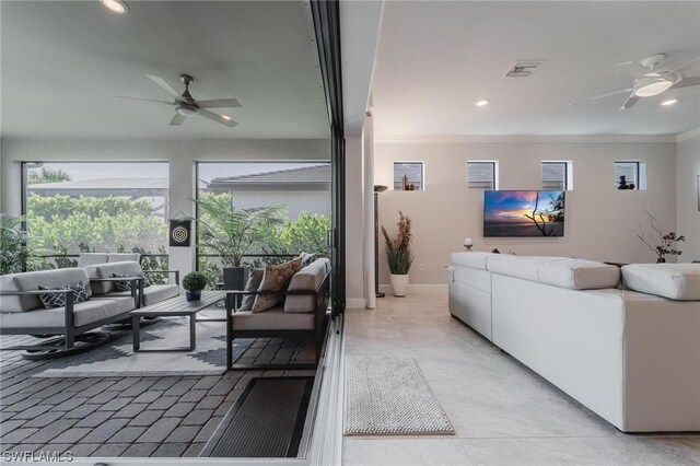 living room featuring ceiling fan, crown molding, and light tile patterned flooring