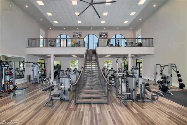 gym featuring hardwood / wood-style flooring and a towering ceiling