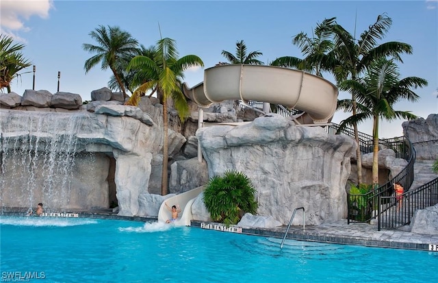 view of swimming pool featuring a water slide and pool water feature