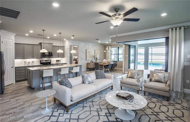 living room with crown molding, sink, and ceiling fan