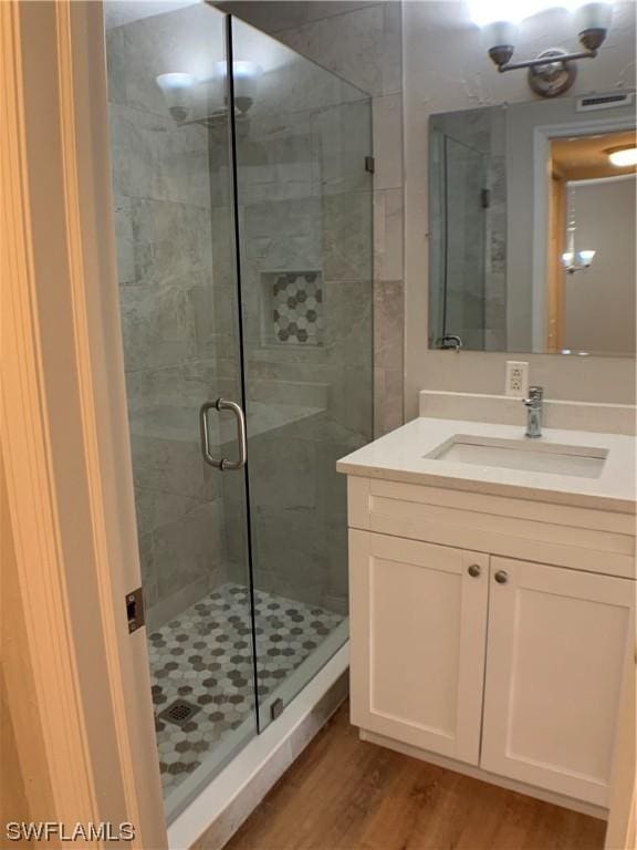 bathroom with vanity, an enclosed shower, and hardwood / wood-style flooring