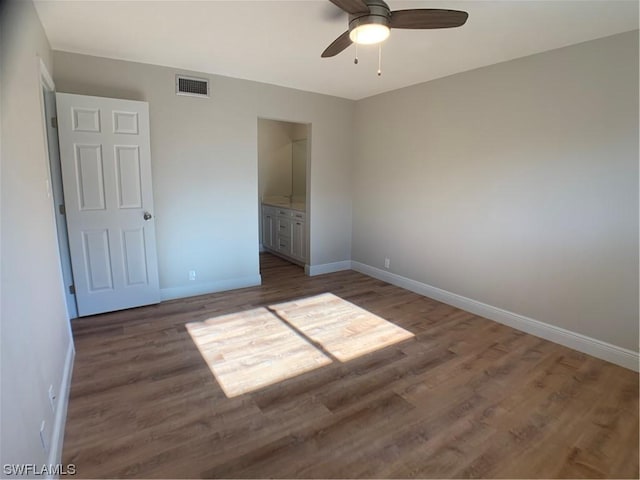 unfurnished bedroom with ceiling fan, dark hardwood / wood-style flooring, and ensuite bath