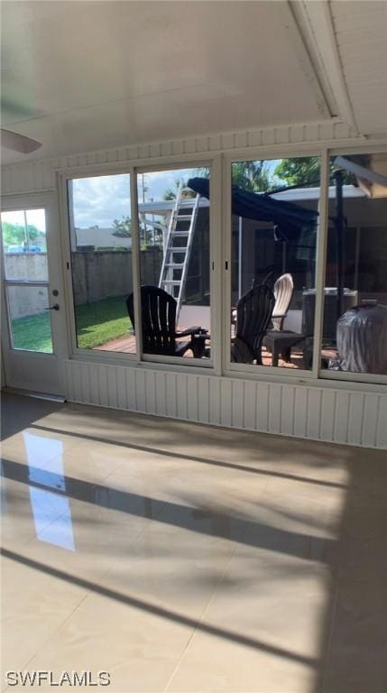 unfurnished sunroom with ceiling fan