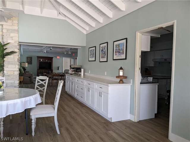 kitchen with vaulted ceiling with beams, white cabinetry, ceiling fan, and dark hardwood / wood-style floors