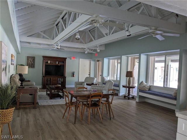 dining room with beam ceiling, hardwood / wood-style flooring, and high vaulted ceiling