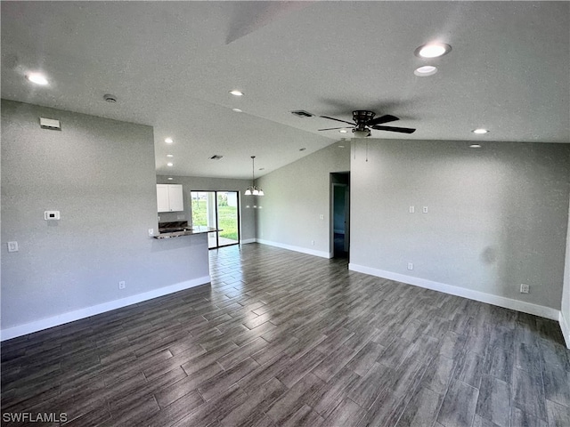 unfurnished room with dark hardwood / wood-style floors, a textured ceiling, ceiling fan, and vaulted ceiling