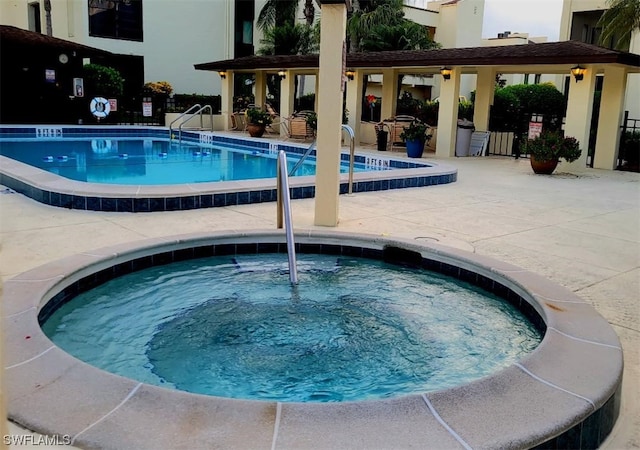 pool featuring a community hot tub and a patio