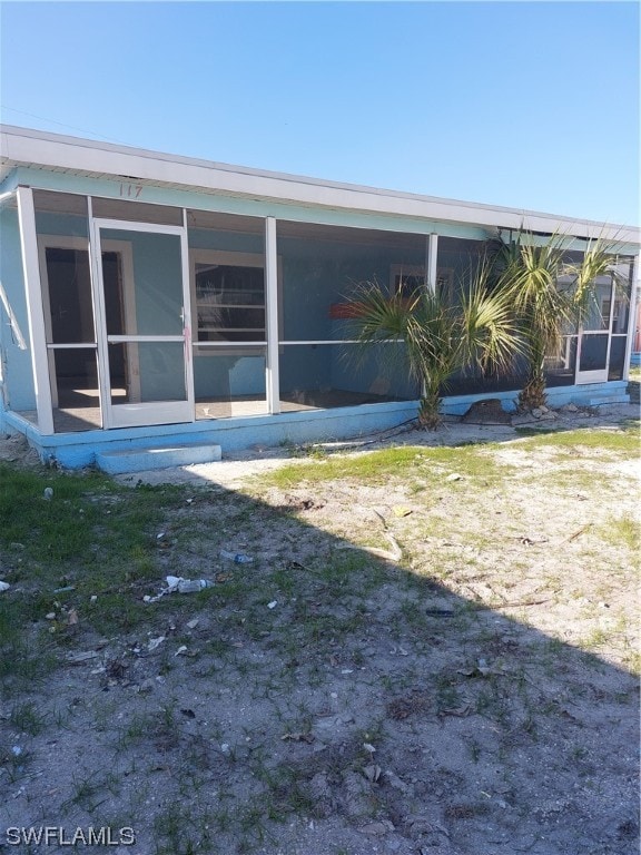 back of property with a sunroom