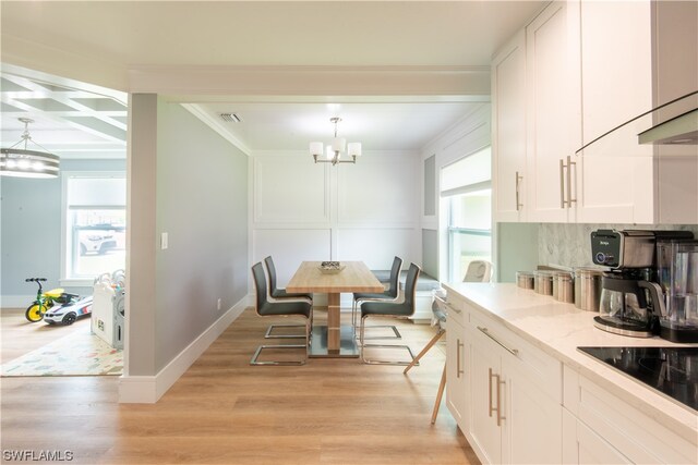 kitchen featuring plenty of natural light, pendant lighting, light hardwood / wood-style floors, and a notable chandelier