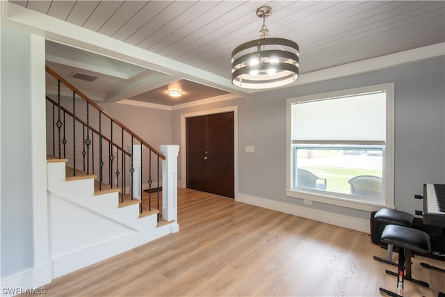 foyer entrance featuring a chandelier, crown molding, light hardwood / wood-style flooring, and beamed ceiling