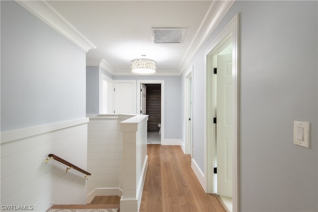 hallway with ornamental molding and light wood-type flooring