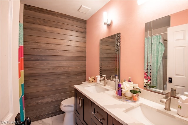 bathroom featuring tile flooring, double vanity, and toilet