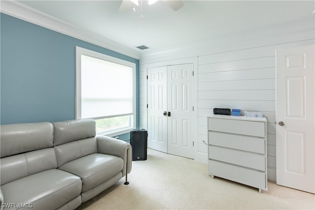 living room with crown molding, ceiling fan, and light colored carpet