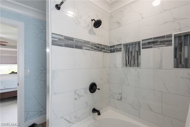 bathroom with crown molding and tiled shower / bath