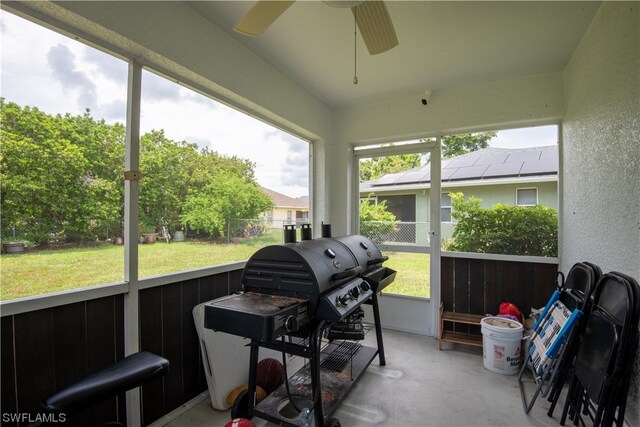 sunroom / solarium featuring a healthy amount of sunlight and ceiling fan