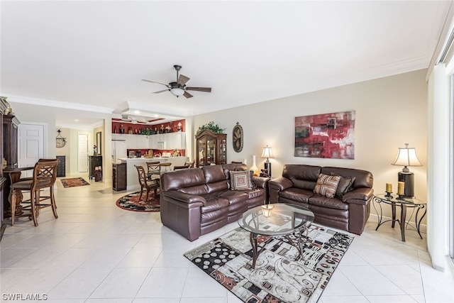 tiled living room featuring ceiling fan and crown molding