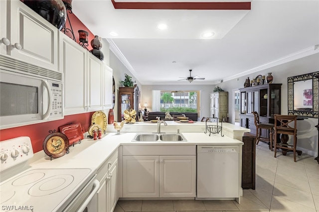 kitchen with kitchen peninsula, white appliances, ceiling fan, sink, and white cabinets