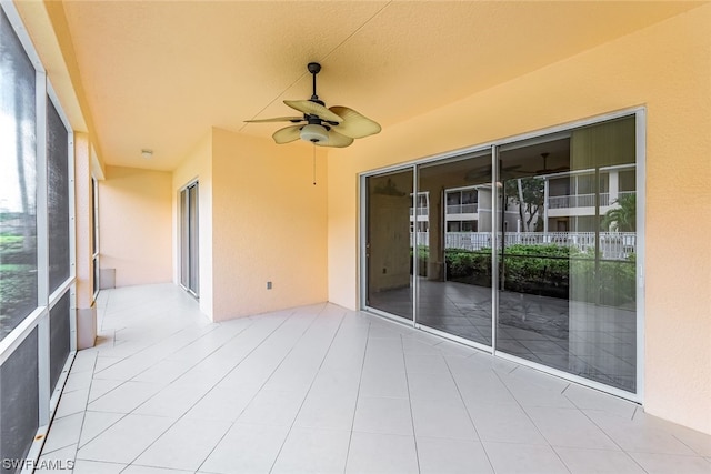 unfurnished sunroom featuring ceiling fan