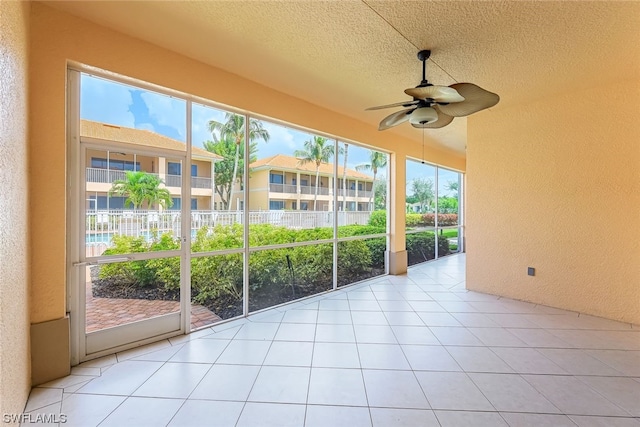 unfurnished sunroom with ceiling fan