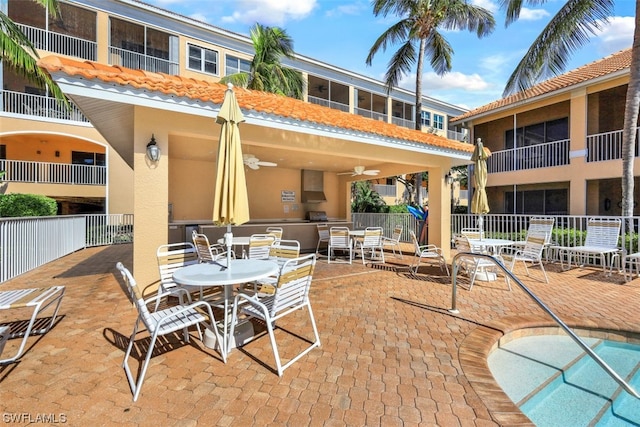 view of terrace with a balcony, ceiling fan, and a pool