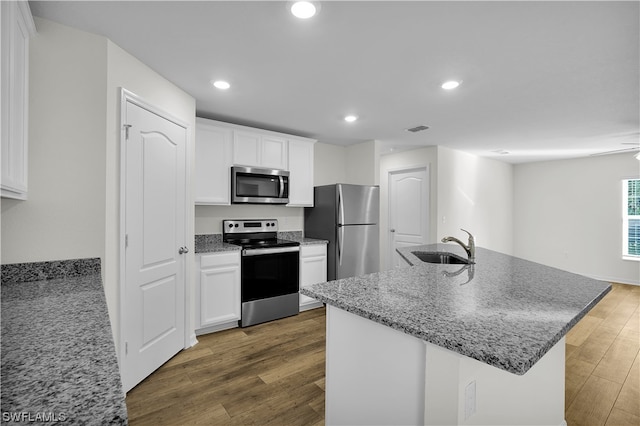 kitchen featuring appliances with stainless steel finishes, white cabinetry, dark hardwood / wood-style floors, and light stone countertops