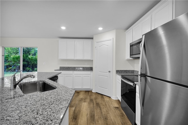 kitchen with sink, light stone counters, dark hardwood / wood-style flooring, stainless steel appliances, and white cabinetry