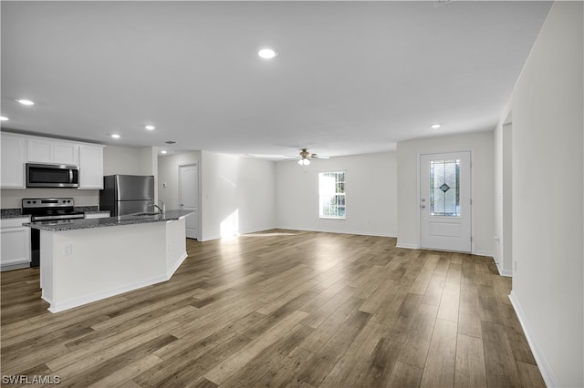 kitchen with white cabinetry, ceiling fan, appliances with stainless steel finishes, and hardwood / wood-style flooring