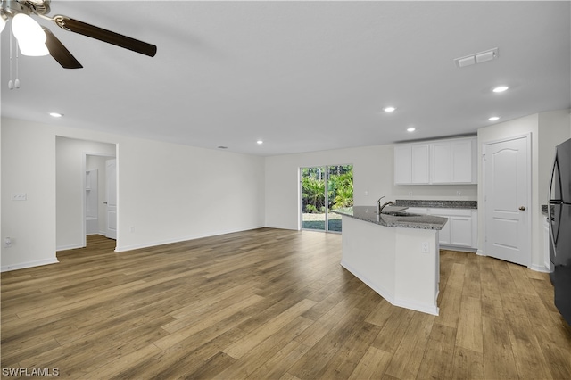 kitchen with white cabinets, sink, and light hardwood / wood-style flooring