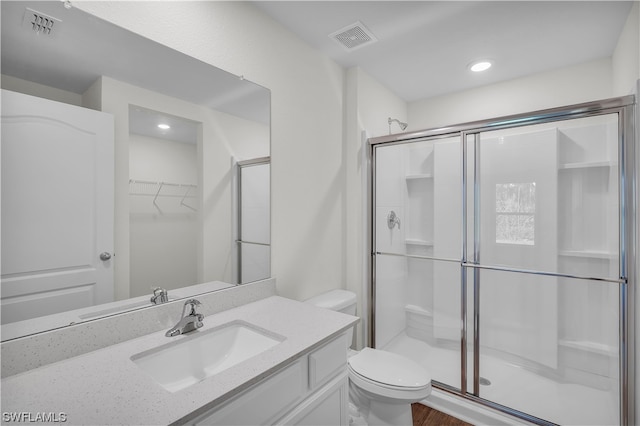 bathroom featuring an enclosed shower, toilet, vanity, and wood-type flooring