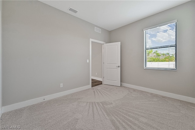 unfurnished room with dark colored carpet