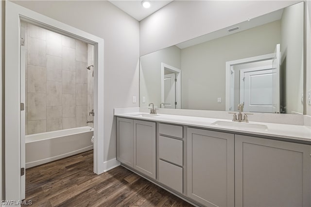 full bathroom featuring bathing tub / shower combination, double vanity, toilet, and wood-type flooring