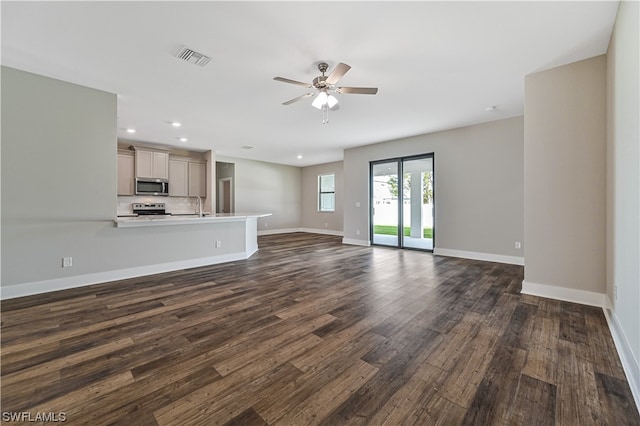 unfurnished living room with ceiling fan, dark wood-type flooring, and sink