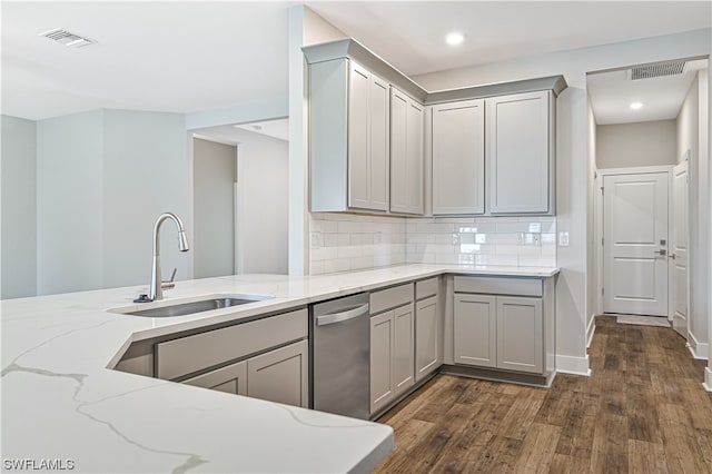 kitchen featuring gray cabinetry, light stone counters, dishwasher, and dark hardwood / wood-style flooring