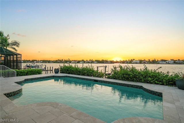 pool at dusk with glass enclosure and a water view