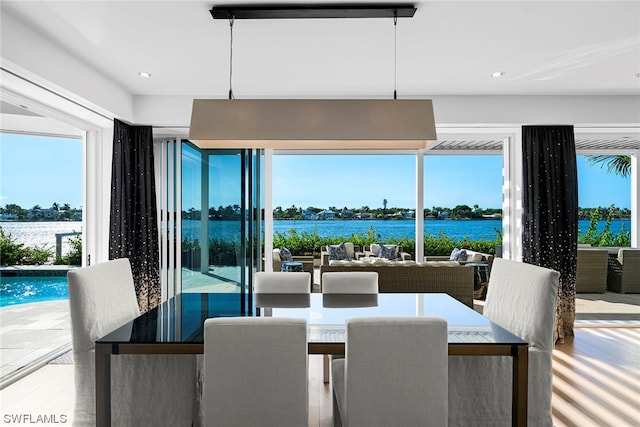 dining area featuring a water view and wood-type flooring