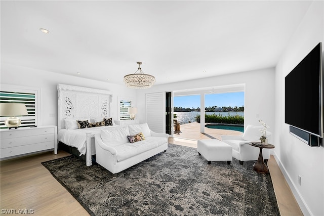 bedroom featuring hardwood / wood-style flooring, a chandelier, and access to outside