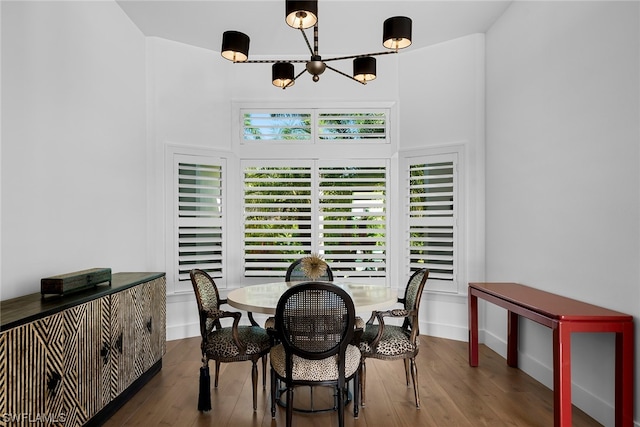 dining area featuring dark wood-type flooring, a chandelier, and a healthy amount of sunlight