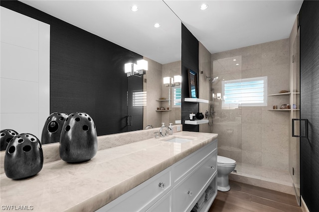 bathroom with an enclosed shower, vanity, hardwood / wood-style flooring, and toilet