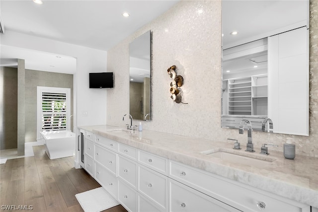 bathroom with vanity, wood-type flooring, and a washtub