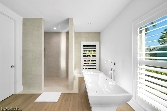 bathroom with plenty of natural light, wood-type flooring, sink, and separate shower and tub