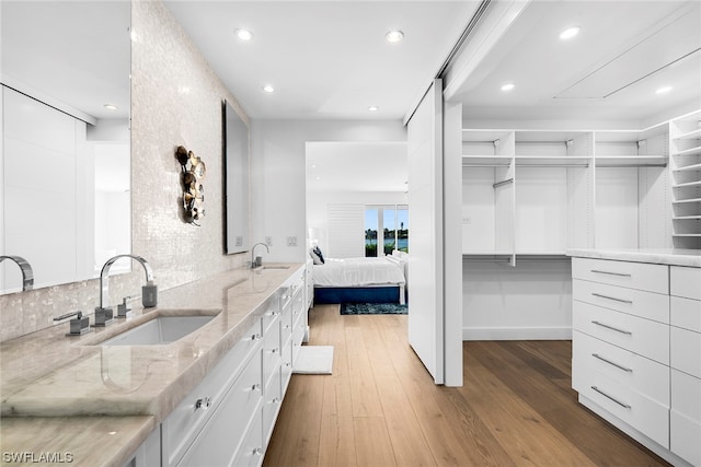 bathroom featuring hardwood / wood-style flooring, vanity, and backsplash