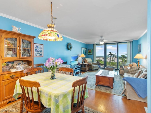 dining space with ornamental molding, ceiling fan, and light wood-type flooring