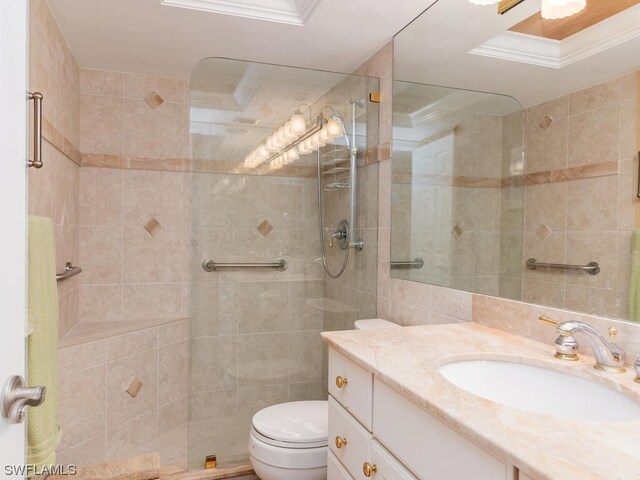 bathroom featuring tile walls, walk in shower, toilet, vanity with extensive cabinet space, and crown molding