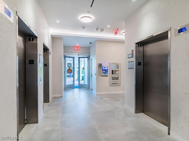 corridor featuring light tile floors and elevator