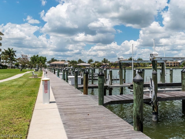 dock area featuring a lawn and a water view